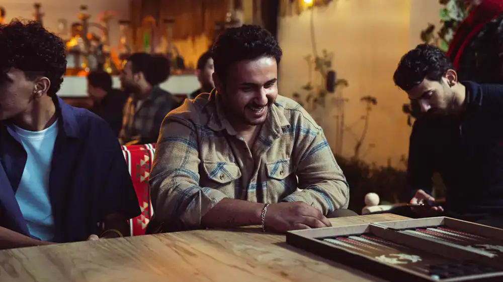 People laughing and playing a board game at a warmly lit cafe table