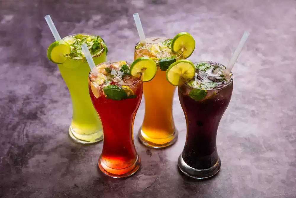 Colorful iced specialty drinks in tall glasses