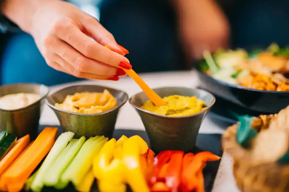 A colorful assortment of plant-based snacks, dips, and vegetables